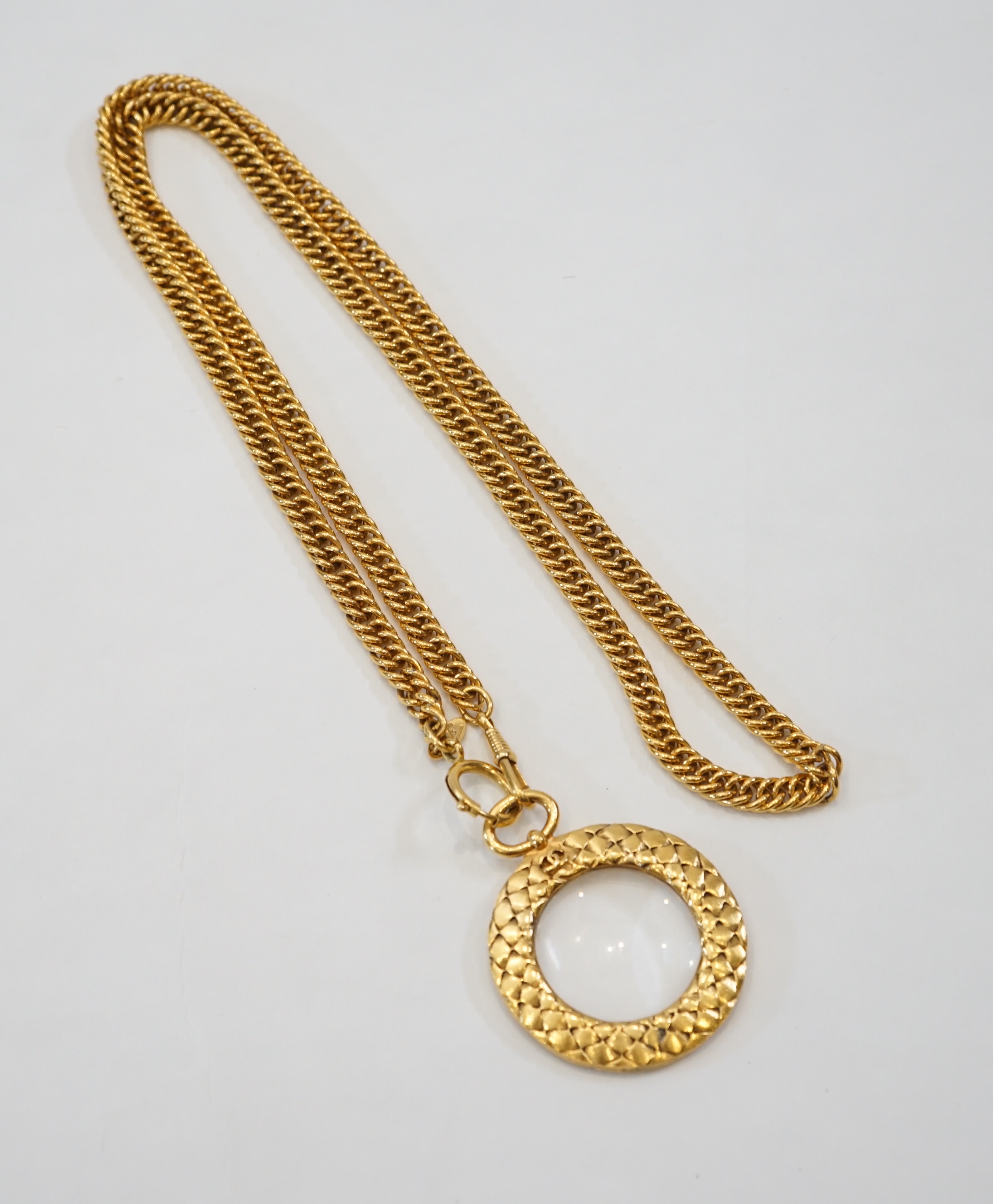 A 1980s Chanel gilt metal 'Scales Textured' magnifying loupe necklace chain length 900mm, pendant width 66mm, height 52mm